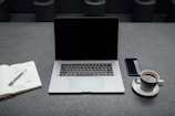 Organized workspace featuring notebooks, coffee cups, and digital devices.