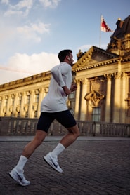 man running near concrete building during daytime