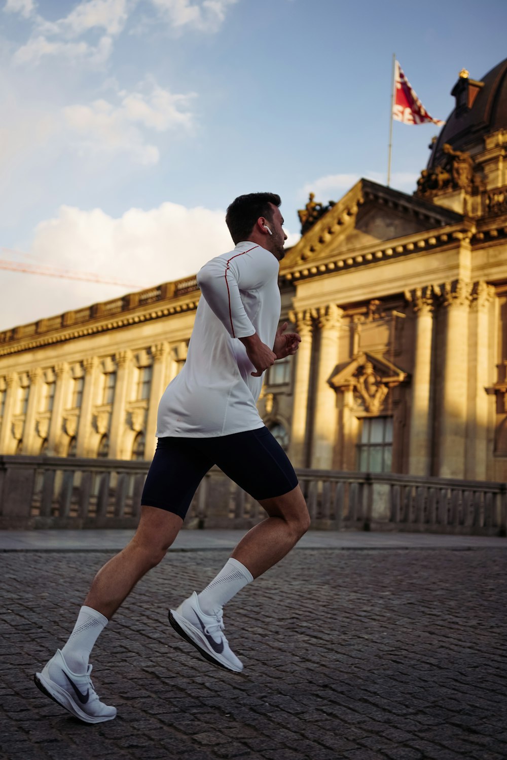 man running near concrete building during daytime