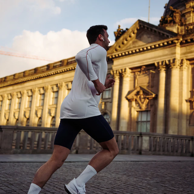 A man running past a concrete building during the day