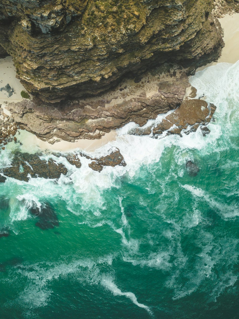 Photographie aérienne d’une falaise près d’un plan d’eau