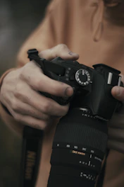 Close-up of hands adjusting a professional camera for a product photoshoot.