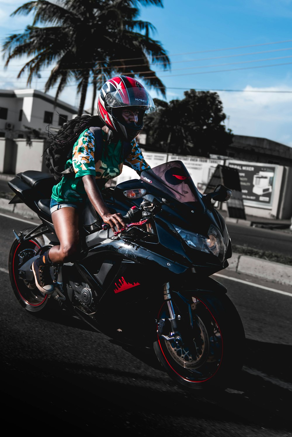 woman wearing green shirt riding on sports bike