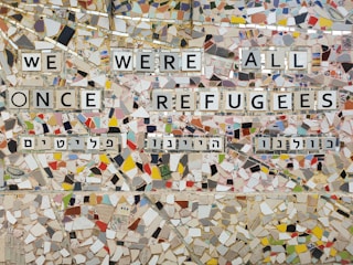 we were all once refugees text on multicolored ceramic tile