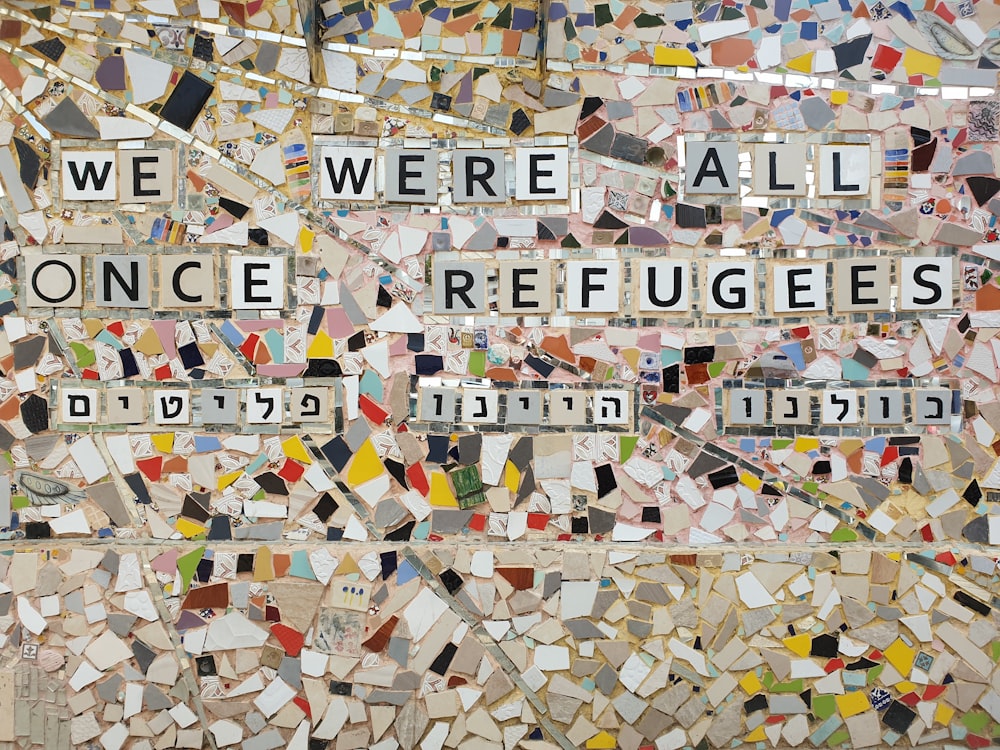 Wir waren alle einmal Flüchtlinge Text auf mehrfarbiger Keramikfliese