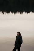 A candid moment of a person reflecting by a calm lake.