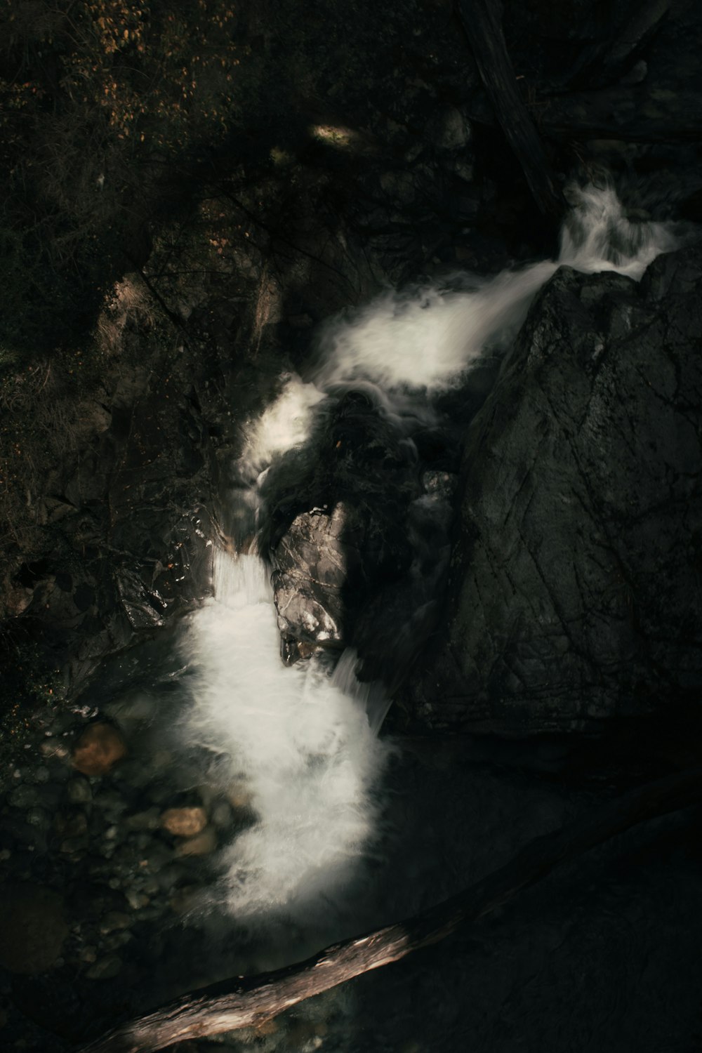 a stream of water running down a rocky hillside