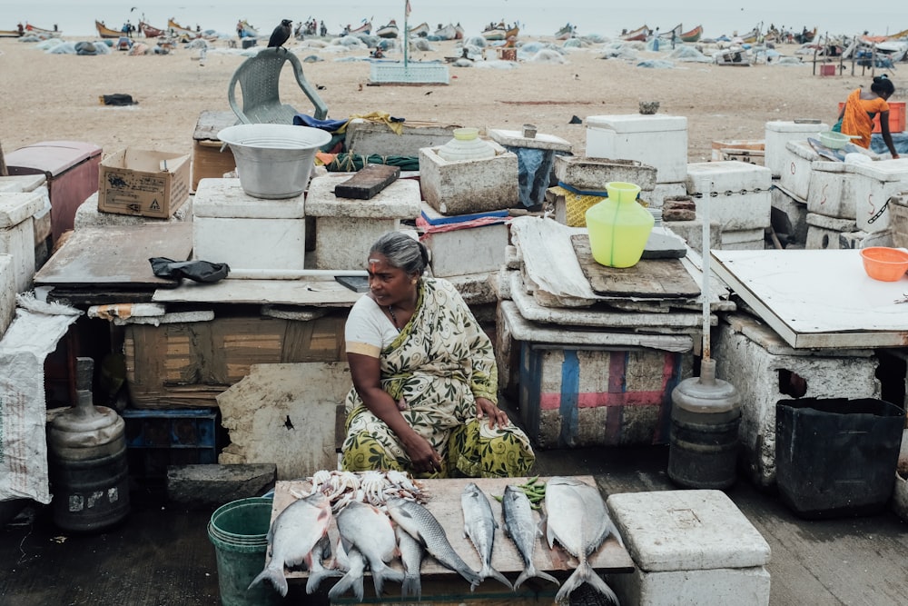 woman sitting on chair while selling fish