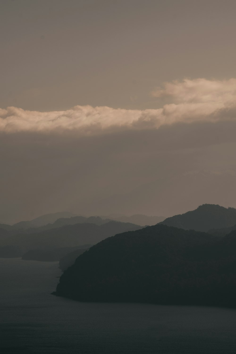 a plane flying in the sky over a body of water