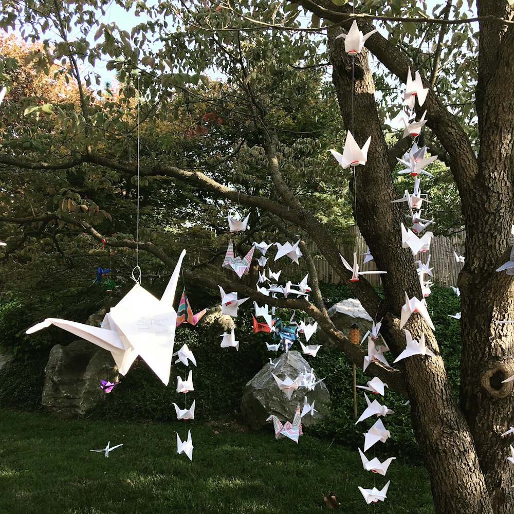 昼間の木に吊るされた白鶴の折り紙