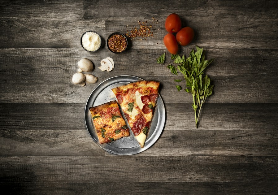 Parts rectangulaires de pizza al taglio servies à la coupe sur plateau
