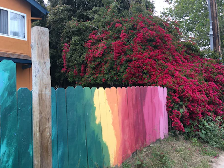 Close-up of a customized fence panel cover in a vibrant color installed in a modern garden.