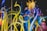 Vibrant glass sculptures rise in twisting, organic forms with vivid colors blending seamlessly. The intricate design showcases a range of translucent tubes and spheres, reflecting light to create a dynamic visual experience.