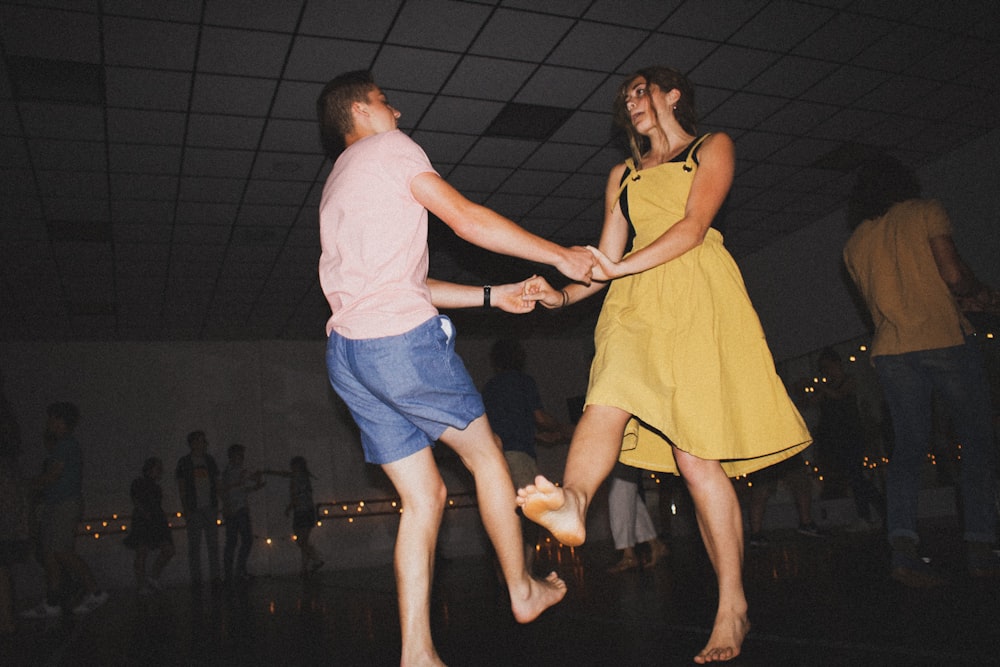 woman in yellow dress dancing with man in white t-shirt