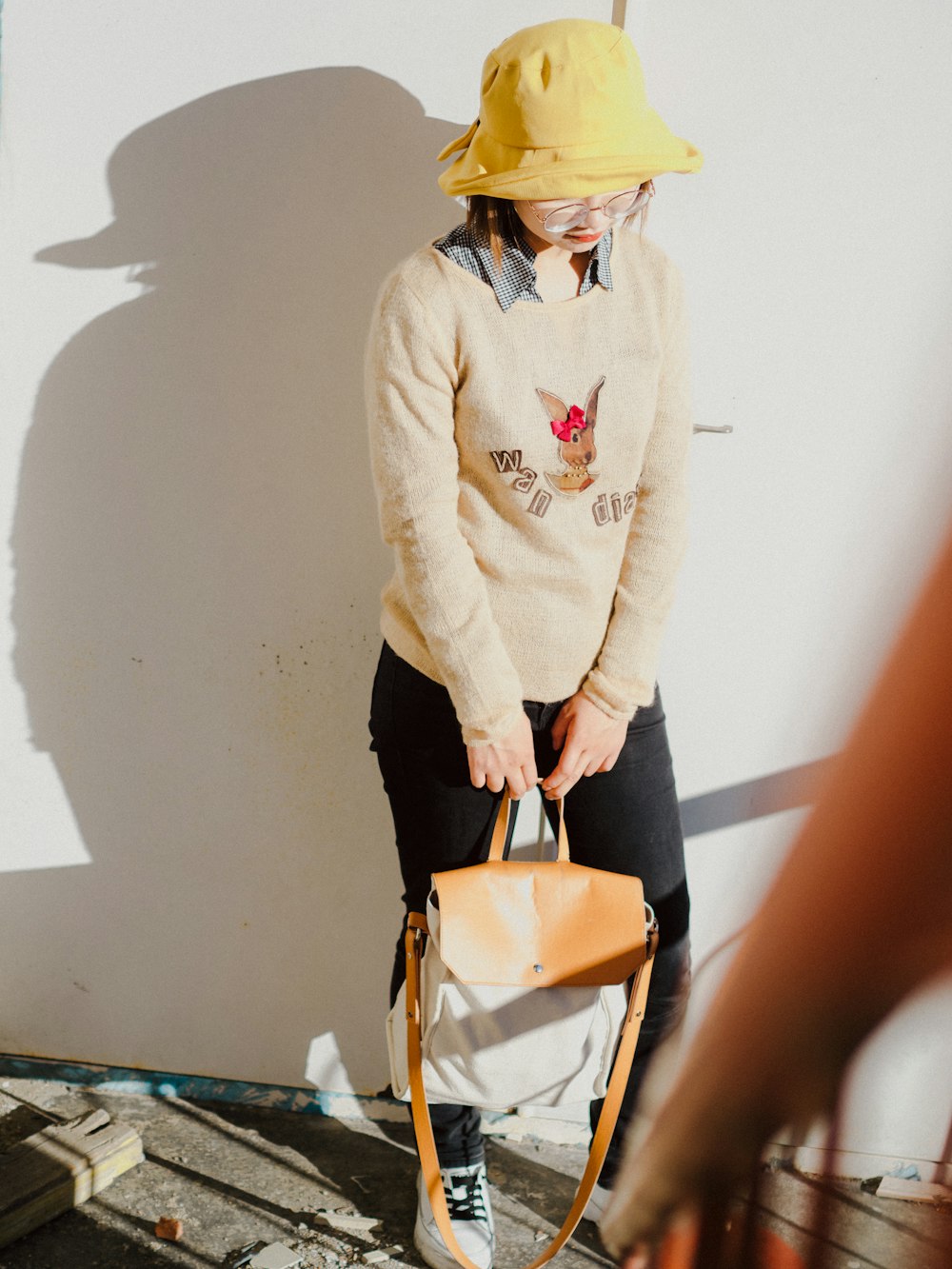 woman wearing brown sweater carrying bag