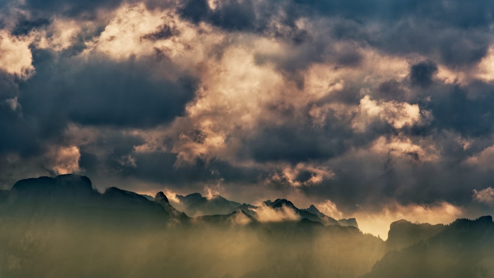 Silhouette von Bergen unter bewölktem Himmel während des Tages