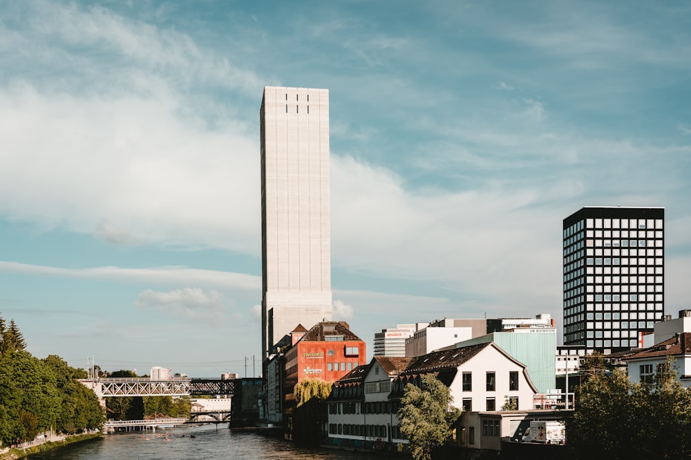 buildings near bridge and body of water during daytime