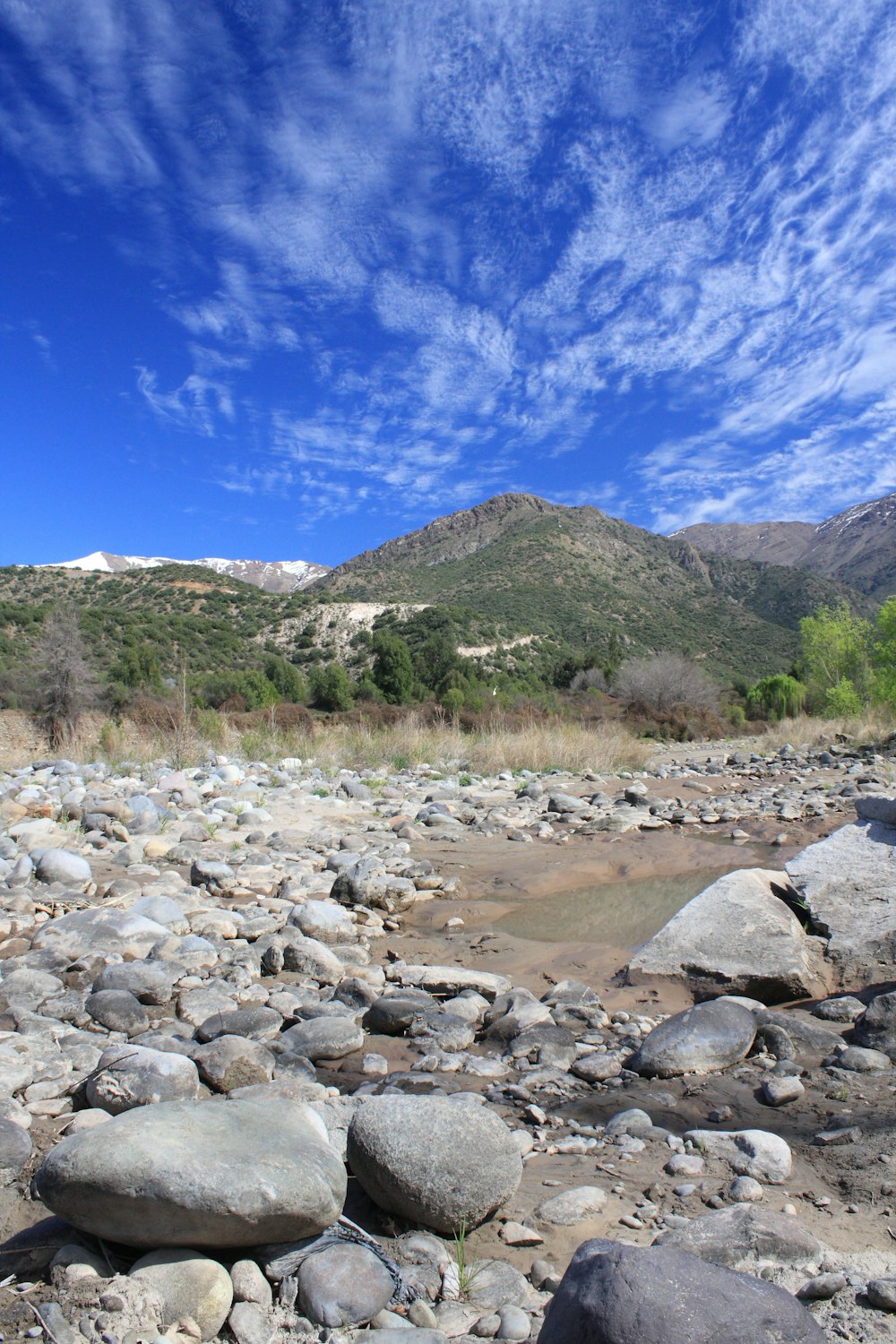 a rocky river bed with a mountain in the background