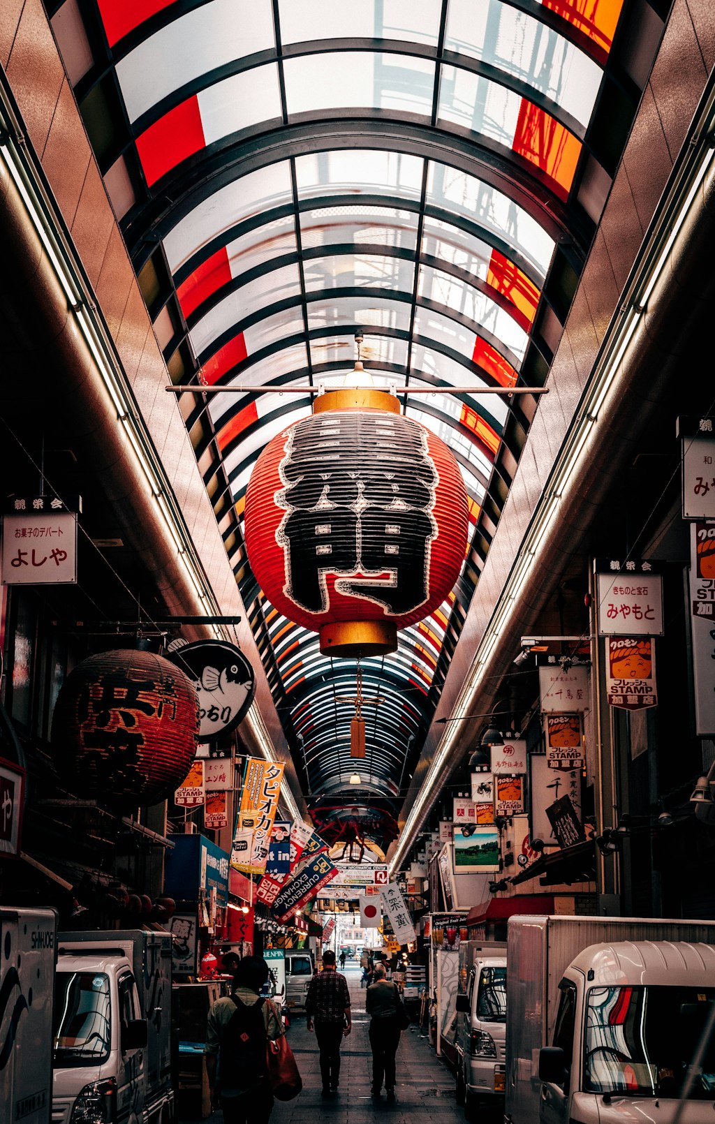 A bustling Tokyo street at night, illuminated by neon signs of shops.