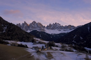 Snow-capped peaks of the Dolomites contrasting with lush green valleys below in northern Italy