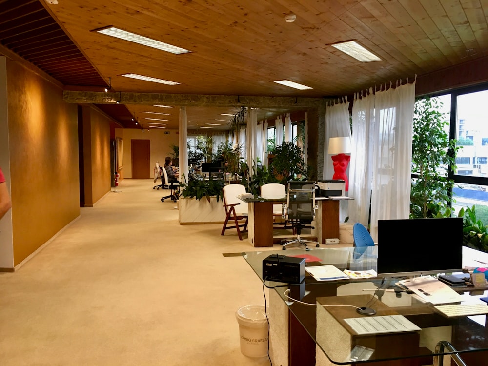 black monitor on table near printer paper on office area of the building with no people