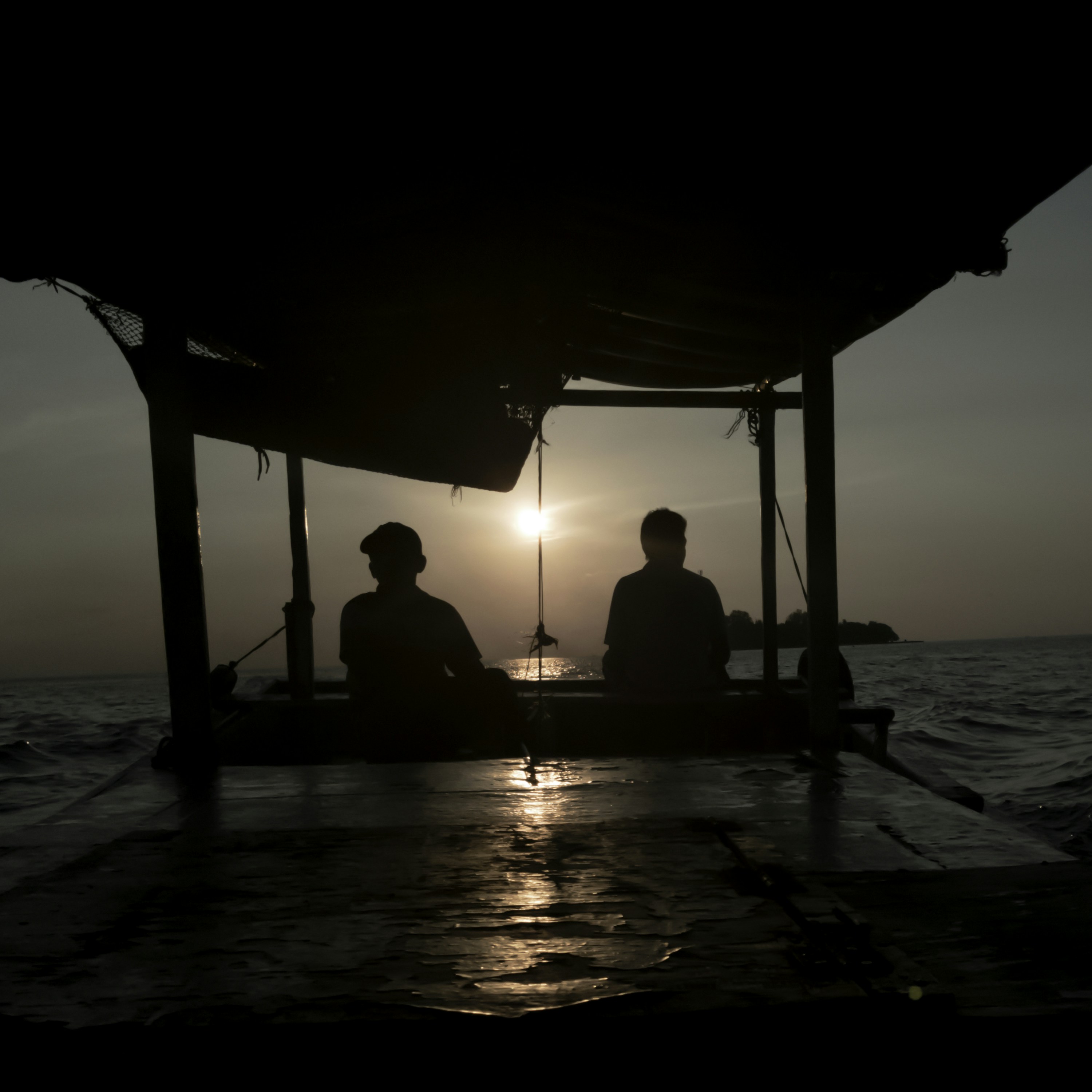 夜海の近くに座っている人の 2 つのシルエットの写真 Unsplashで見つける日没の無料写真