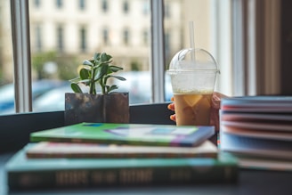 selective focus photo of person holding clear disposable cup