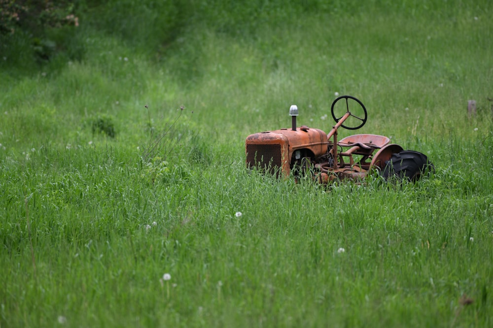 tractor naranja en campo de hierba verde durante el día