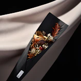 Elegant floral arrangement wrapped in textured clay-colored paper with gentle shadows.