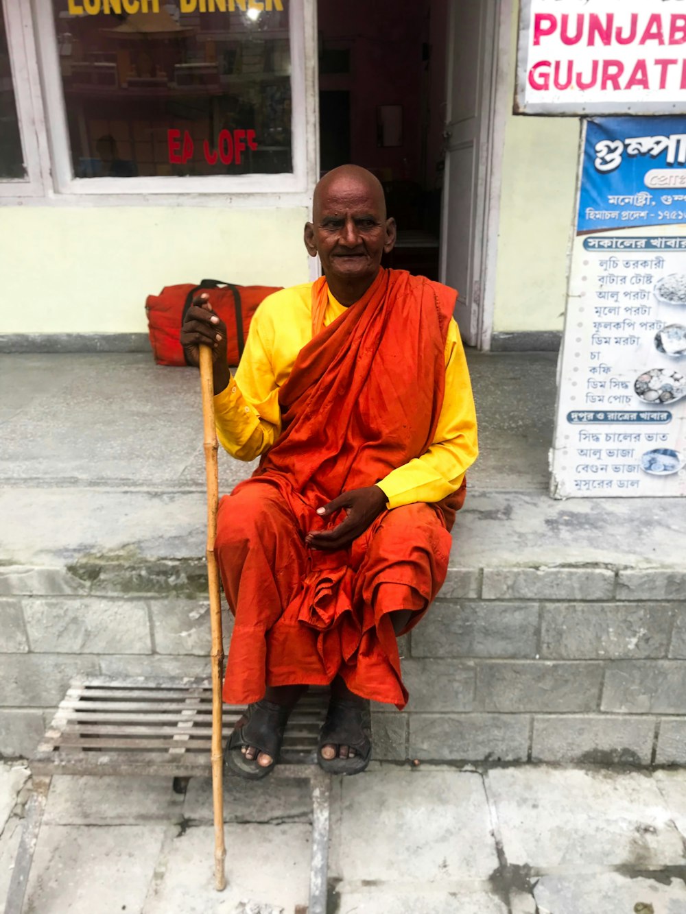 man sitting outdoor holding stick