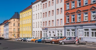 assorted-color cars parked beside apartments