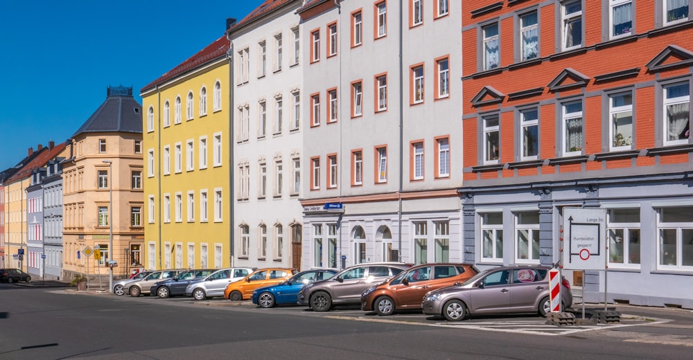 assorted-color cars parked beside apartments