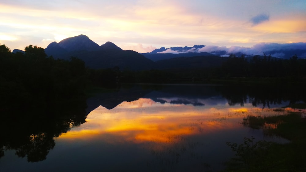 orange sunset in lake surrounded with trees