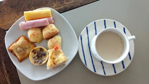 Tea and coffee service with fresh pastries on a small table.