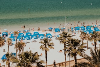 blue and white tents in beach with people