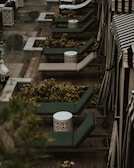 Outdoor recliner with cushions placed on a wooden deck surrounded by greenery.
