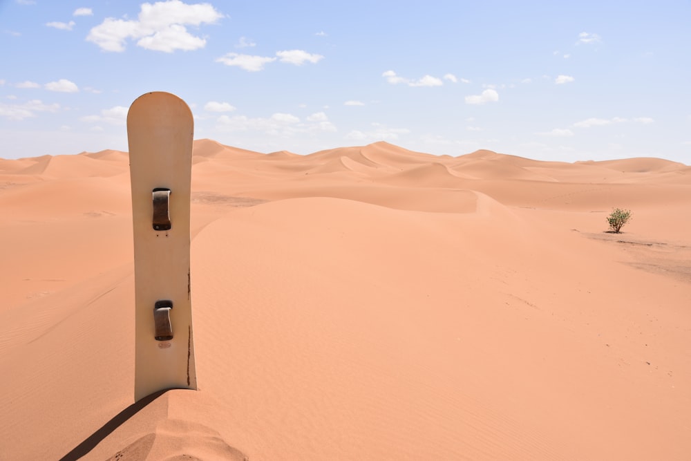 brown and black skateboard on sand dunes