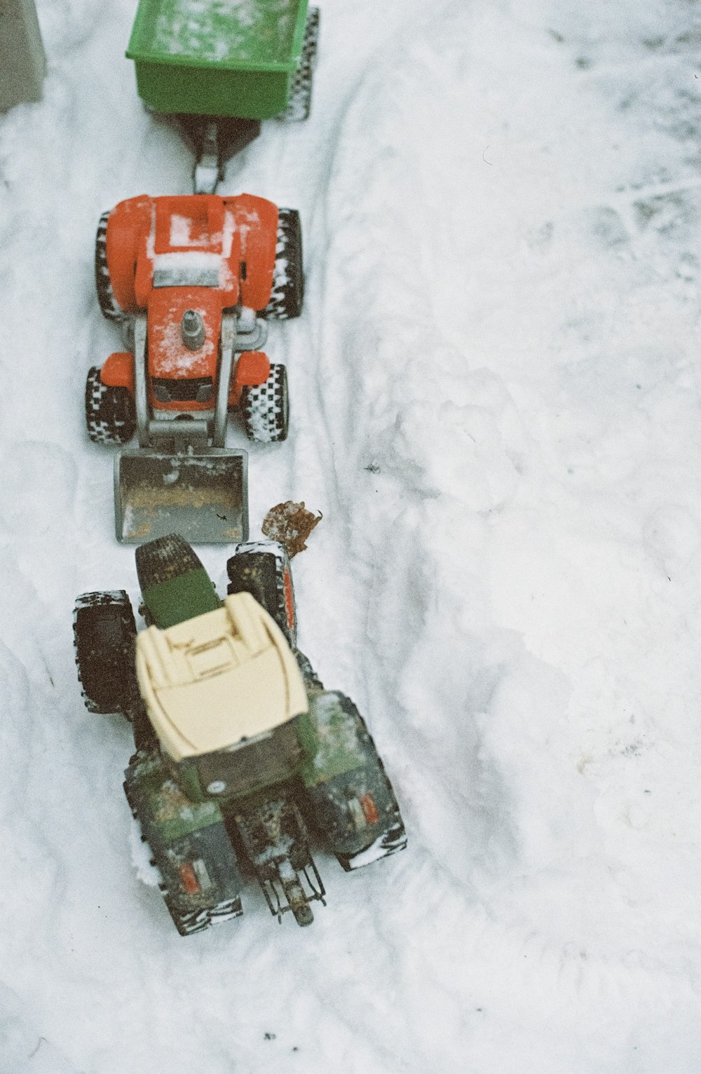 Tres juguetes de vehículos rojos en la nieve