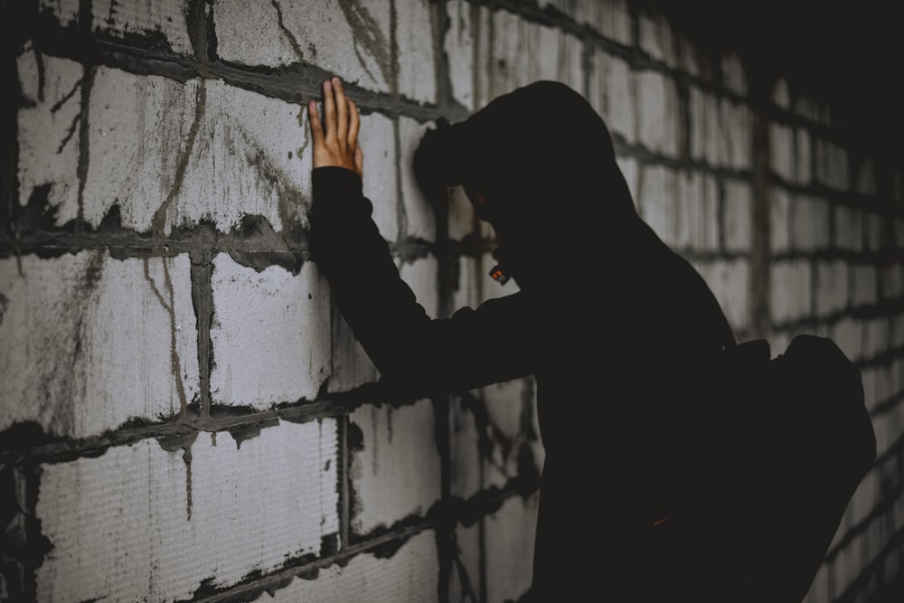 man leaning on wall