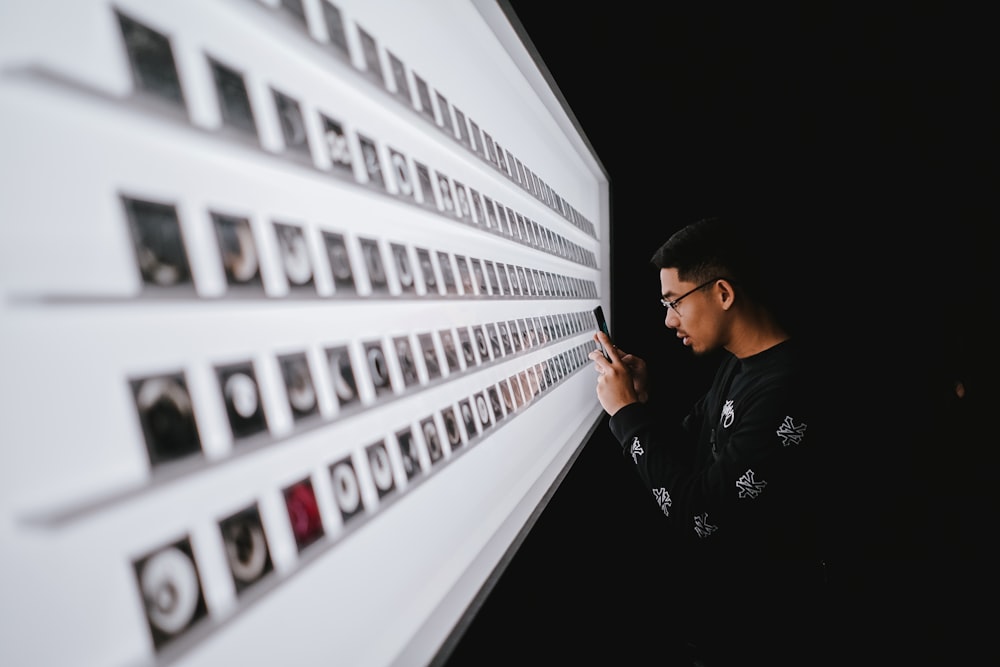 uomo in piedi durante l'utilizzo dello smartphone