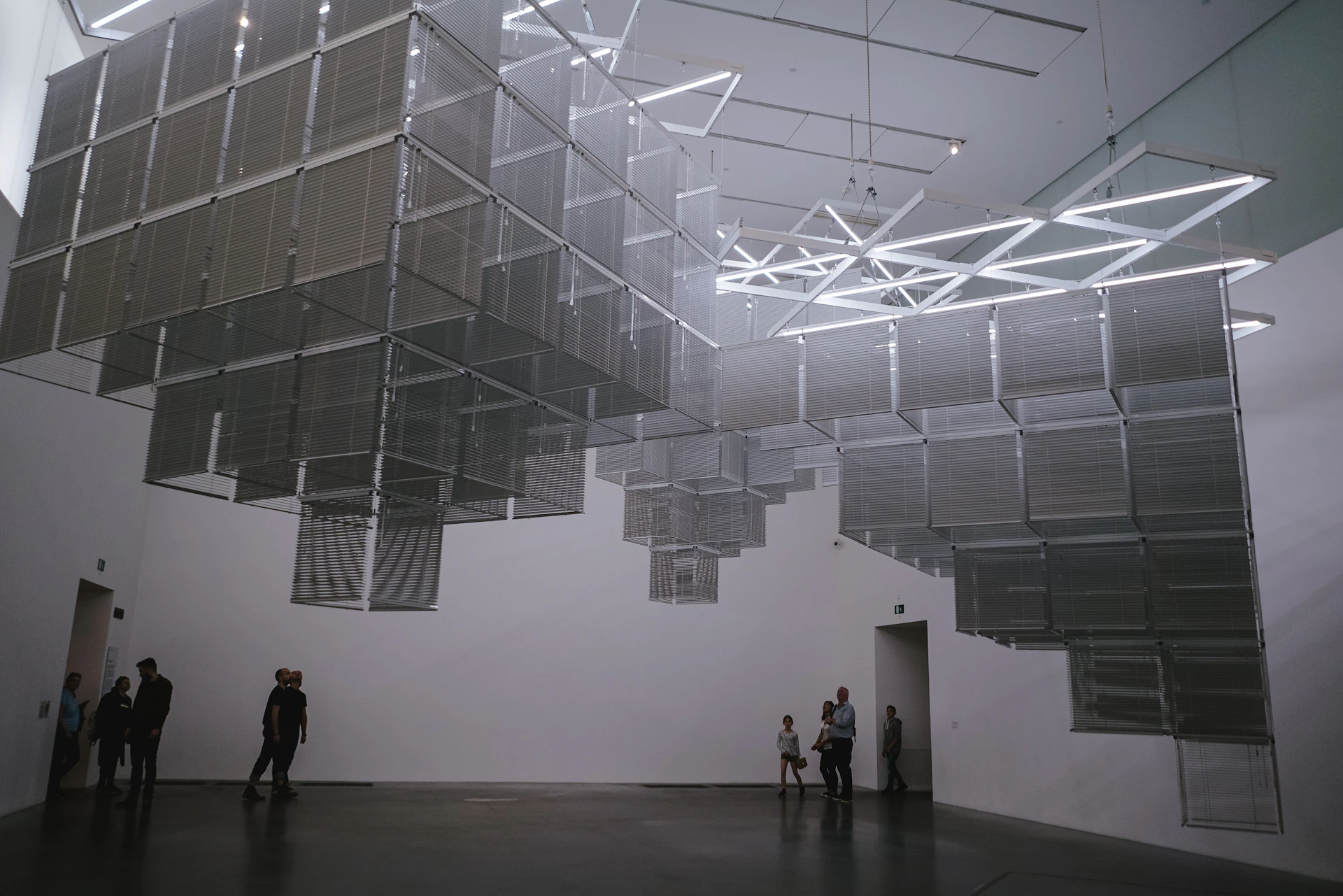 Close-up of a contemporary art installation featuring geometric shapes and shadows, emphasizing the interplay of light and form.