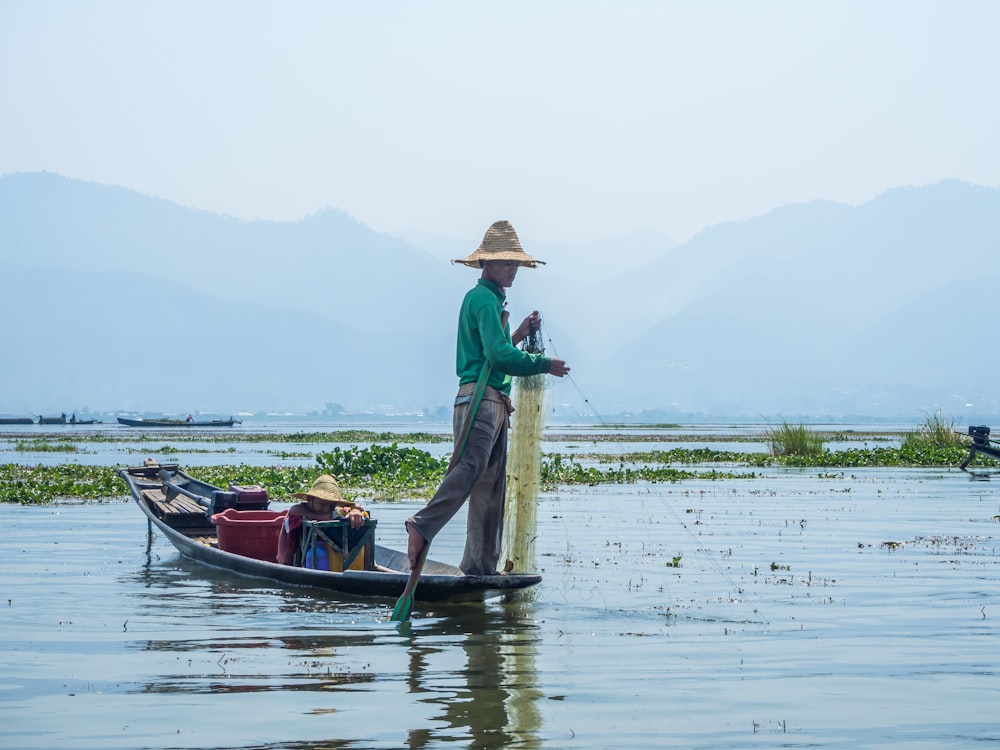 photography of man standing on brown boat during daytime