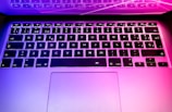 A close-up of a sleek laptop keyboard with colorful backlighting.