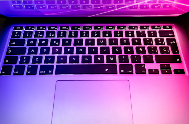 Detailed photo of a laptop keyboard with vibrant cyber-style backlighting.