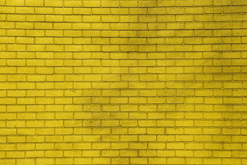 a yellow brick wall with a red fire hydrant