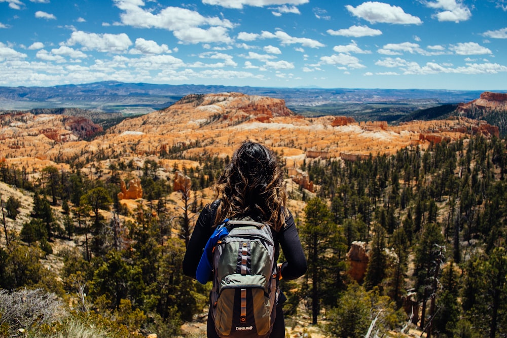 woman carrying gray and brown backpack