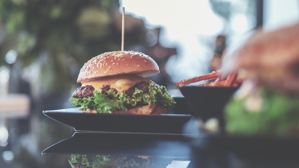 burger with lettuce and cheese on a plate