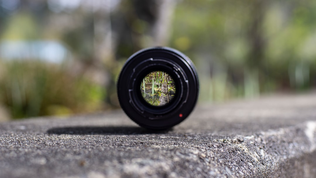 black DSLR camera lens on concrete surface,