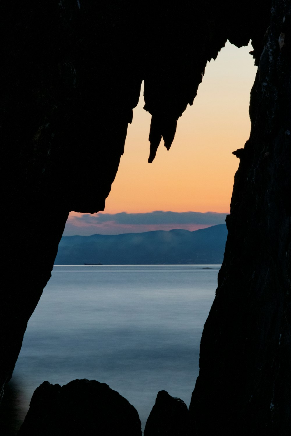 a view of a body of water through a cave