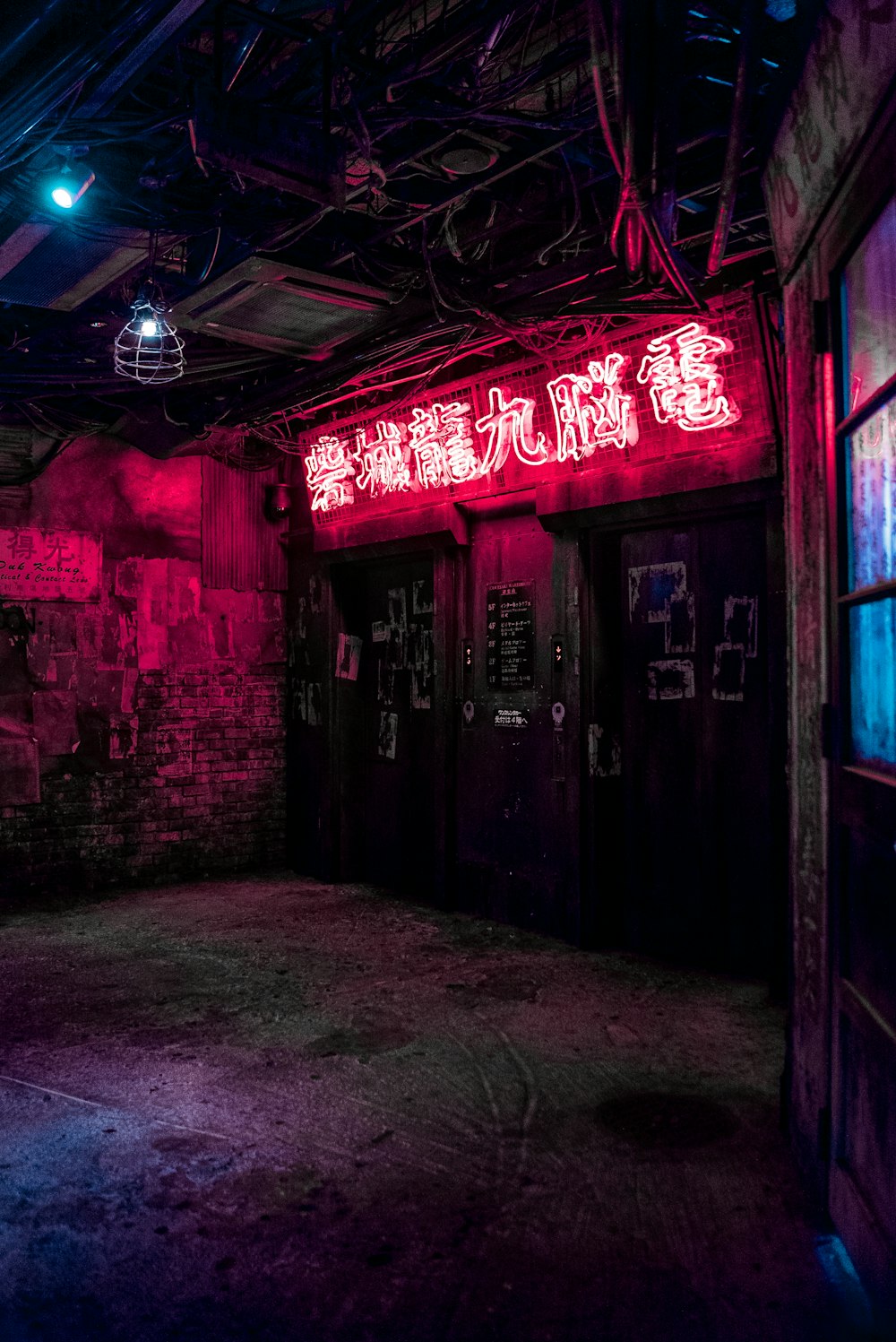 a dark room with a neon sign above the doors
